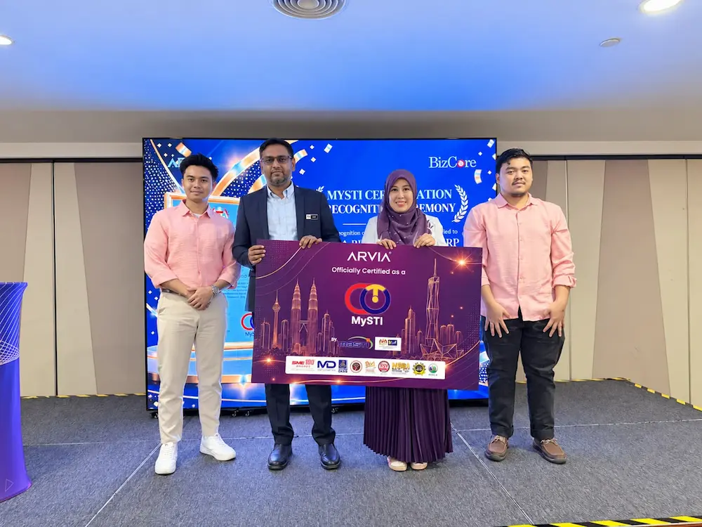 MOSTI handing over the Bizcore ERP MYSTI Certification foamboard mockup to Arvia Solutions