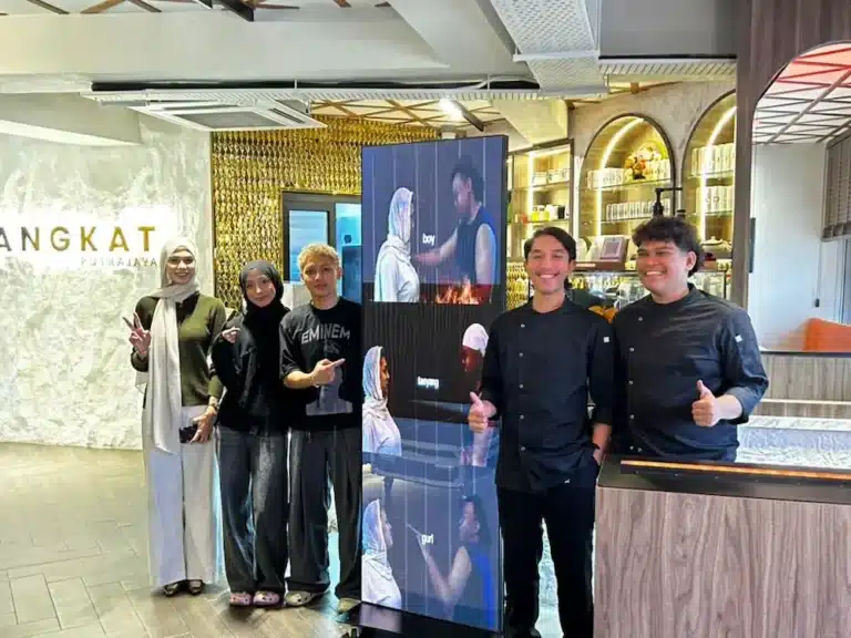 Changkat Cafe team beside the Arvia LED poster for cafe playing video content in Putrajaya