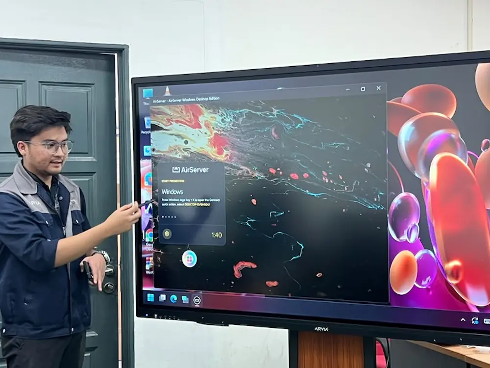 Arvia team demonstrating wireless screen sharing from multiple devices on the smartboard AI Arvia at Perda Tech, Penang