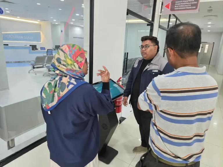Arvia team explaining the touchscreen monitor kiosk Kedah display to PDWU staff